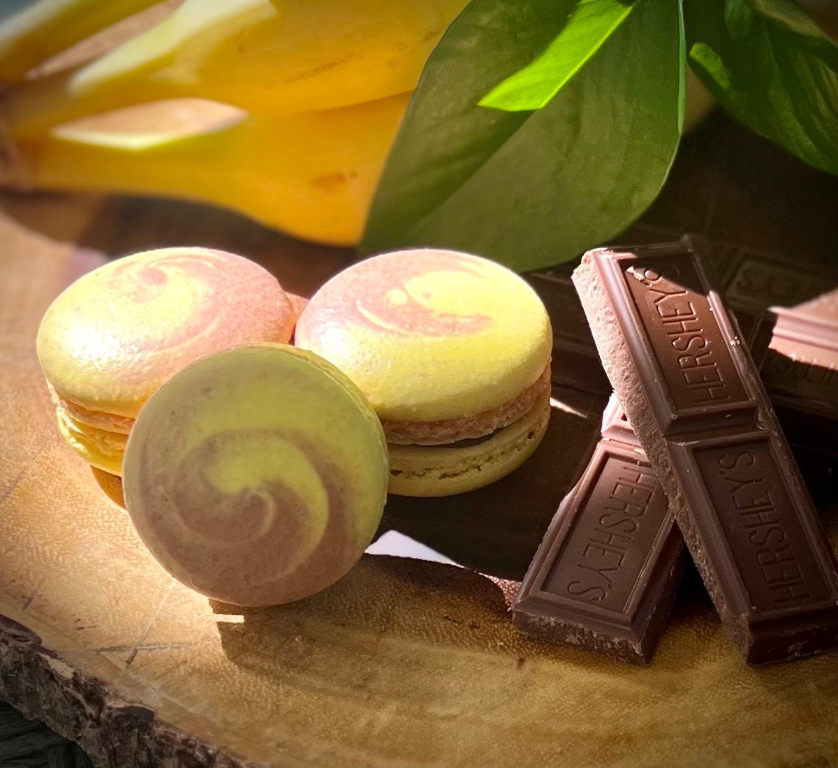 Yellow and chocolate-swirled banana chocolate macarons with bananas and chocolate bars