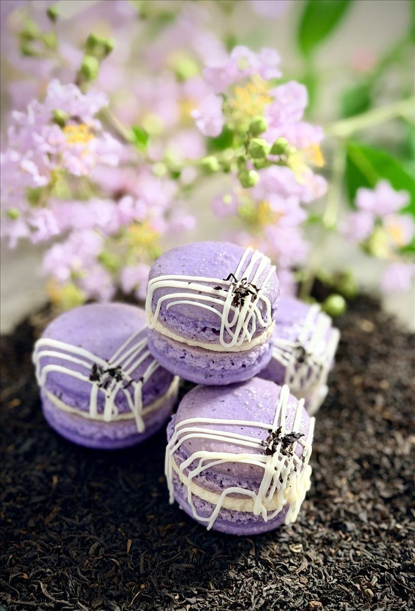 Purple Earl Grey macarons decorated with white chocolate and tea leaves