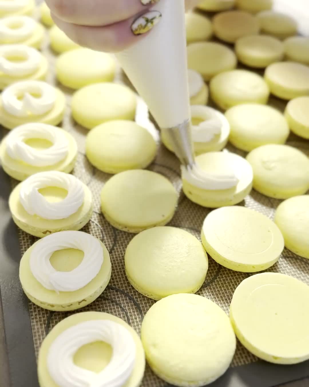 Buttercream piped in a ring onto macaron shells, then filled with lemon curd
